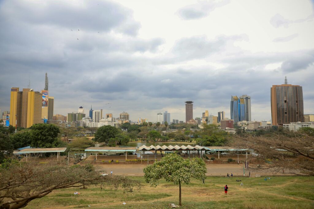 A vibrant shot of Nairobi's skyline featuring skyscrapers like KICC and local landmarks under a cloudy sky.